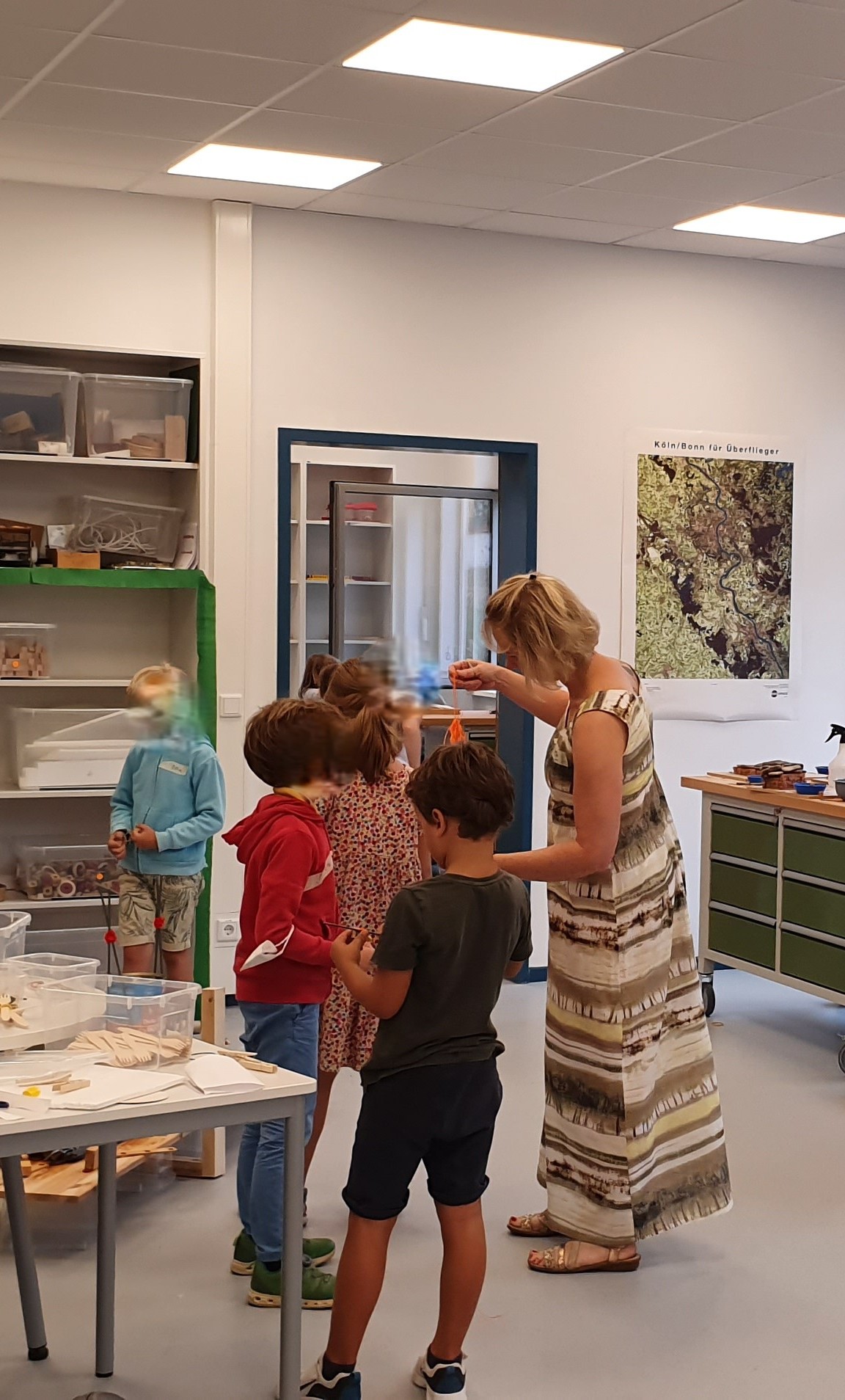 Pädagogin gibt Kindern in der Lernwerkstatt einen Materialimpuls